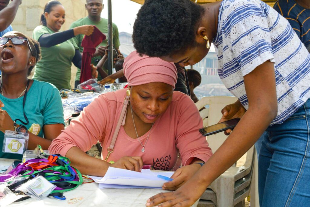 Group of volunteers working on registration at a community event outdoors.