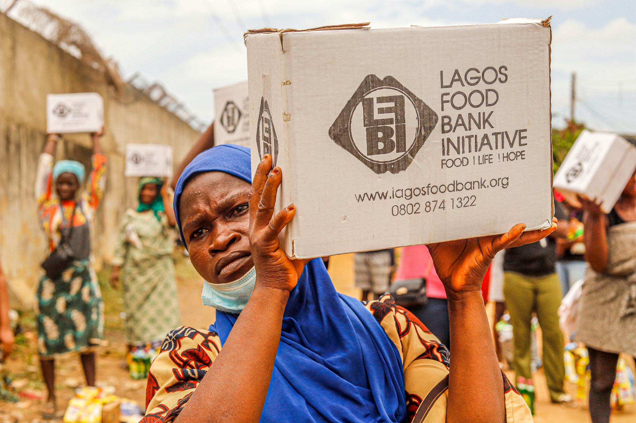 Community members engage in food distribution at Lagos Food Bank initiative event.